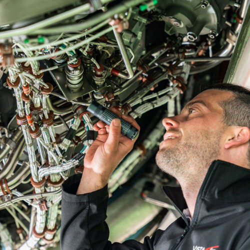 Vista engineer examines the internals of a jet engine